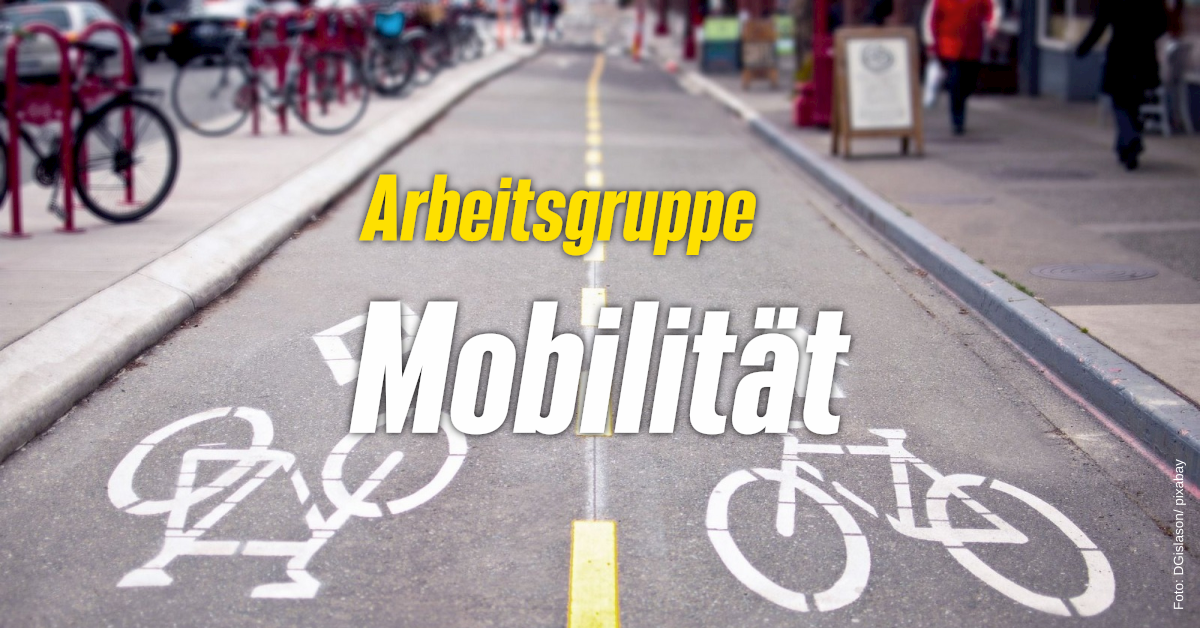Auf dem Bild ist eine Fahrradstraße zu sehen. In gelber und weißer Schriftbsteht "Arbeitsgruppe Mobilität" auf dem Bild drauf.