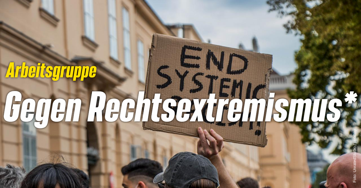Auf dem Bild ist ein Demoschild zu sehen. Auf diesem steht "end systematic racsim". In gelber und weißer Schrift sthet auf dem Bild "Arbeitsgruppe gegen Rechtsextremismus*".